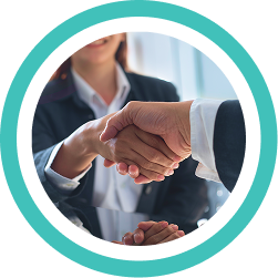 Two people in business attire shaking hands across a table, signifying a partnership in support coordination services.